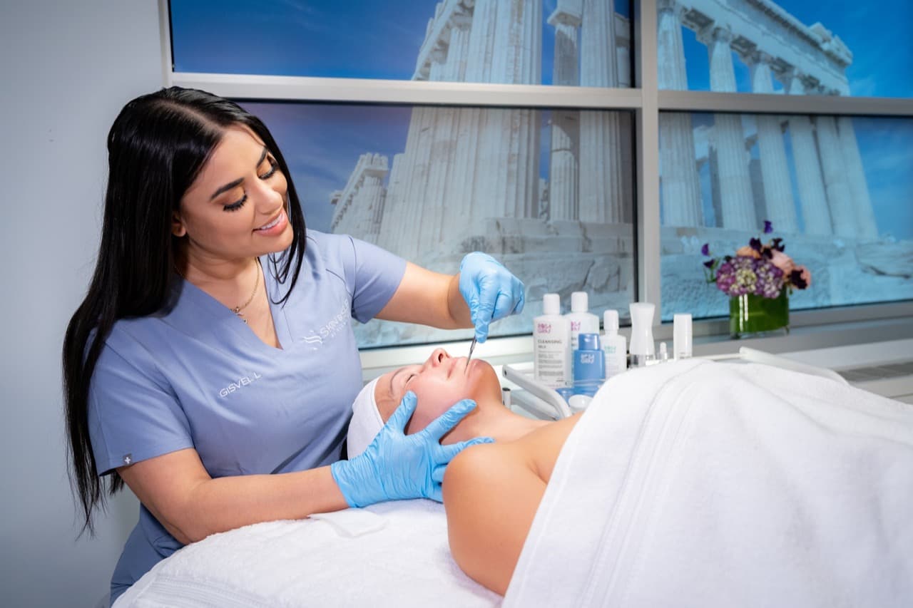 Una esteticista de Skin & Self realizando un tratamiento facial